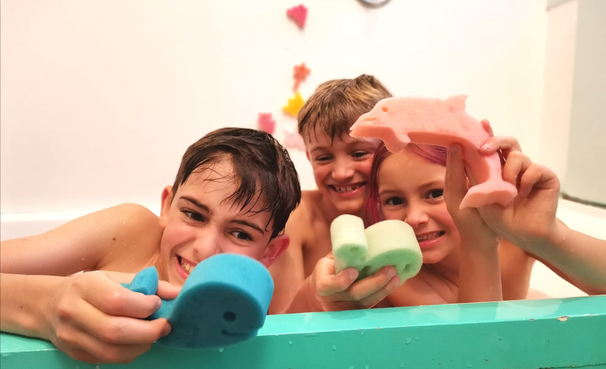 Three kids in the bath holding Jumbo sponge toys
