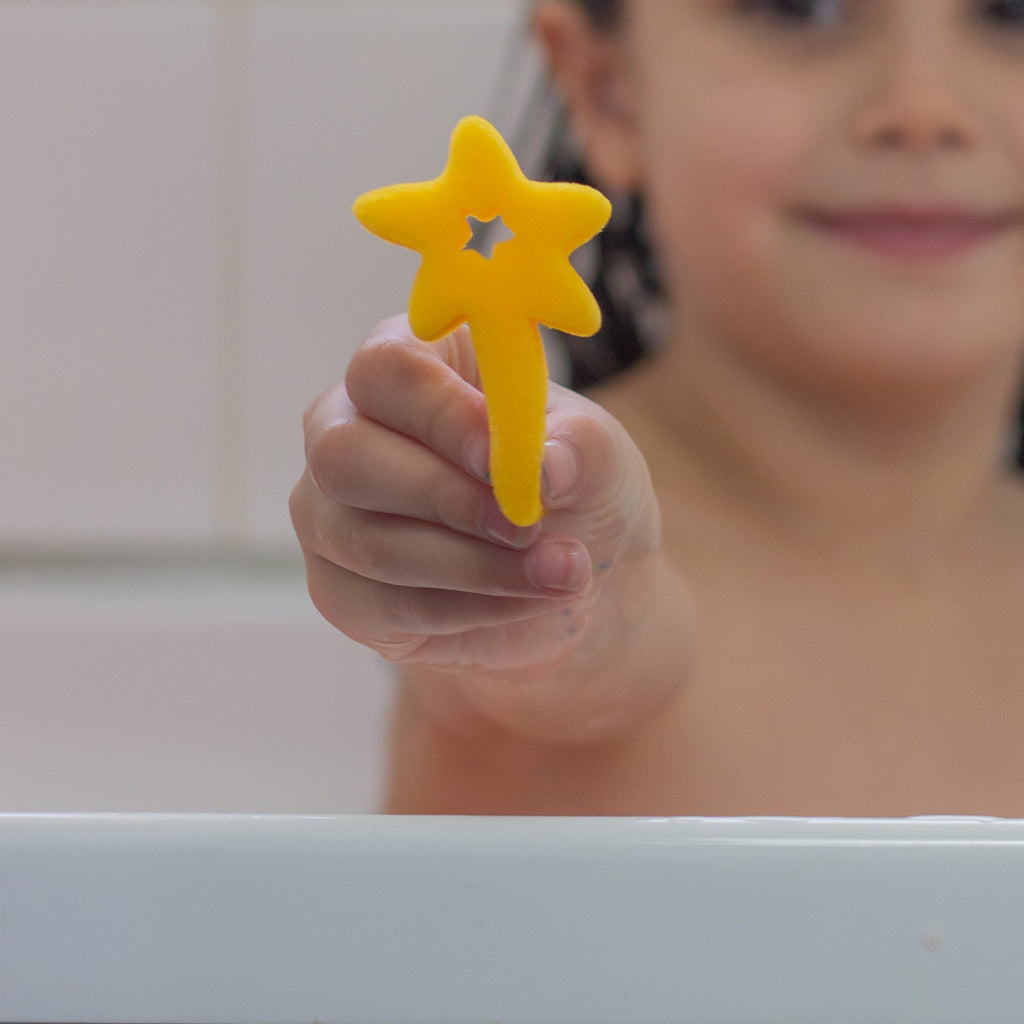 Child holding a yellow star wand sponge toy