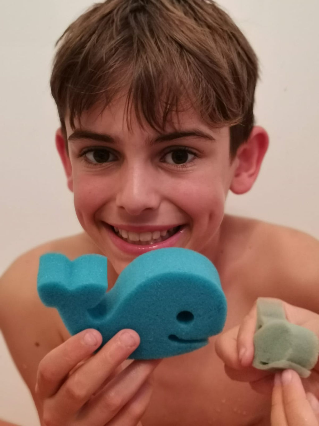 Boy holding a blue whale sponge toy from a Jumbo Bath Bomb Sprudel