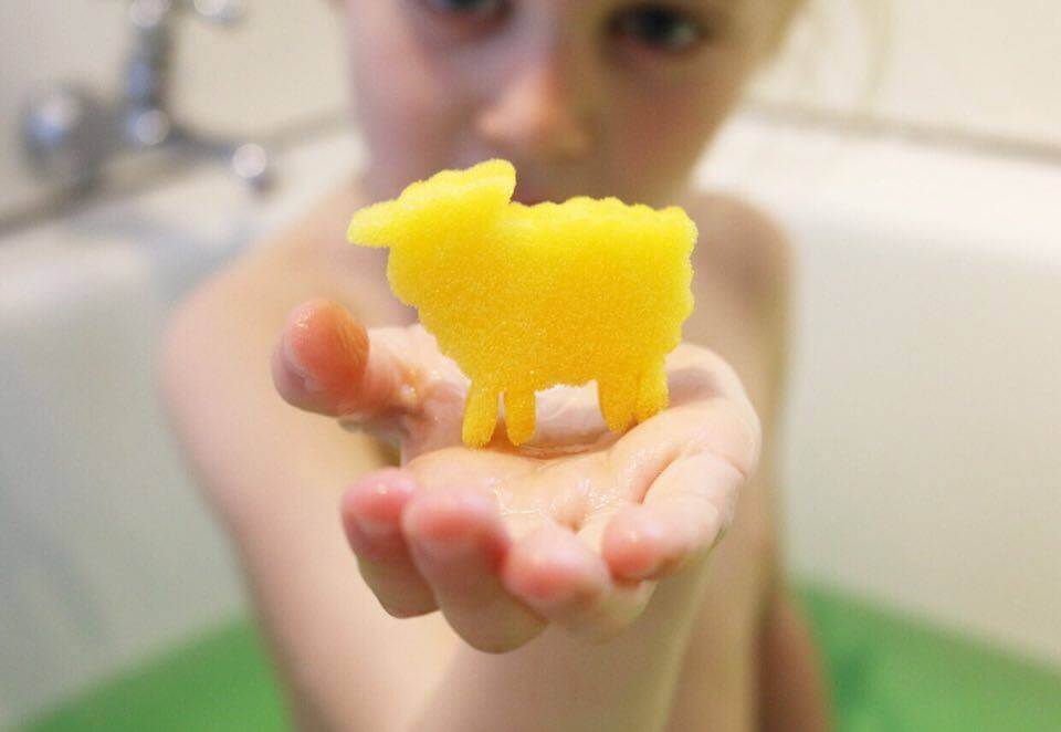 child holding sponge toy from bath buddies kids bath bomb
